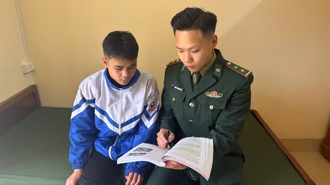Trung úy Hoàng Trung Kiên hướng dẫn con nuôi Đồn biên phòng làm bài tập.