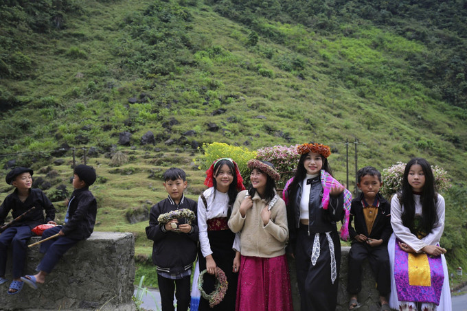Du khách và trẻ em vùng cao rạng rỡ trong sắc hoa Tam giác mạch trên Cao nguyên đá Đồng Văn.