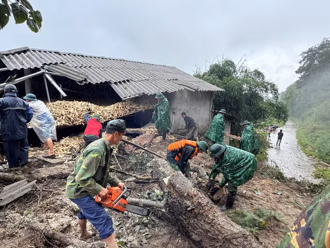 Cán bộ, chiến sĩ Đồn Biên phòng Lũng Cú khẩn trương dọn dẹp, dựng lại nhà cho người dân vùng ảnh hưởng của bão số 10. Ảnh: TTXVN phát