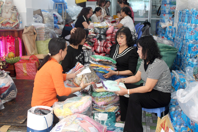 Các thành viên trong Câu lạc bộ Di sản áo dài Việt Nam- Bình Thuận (tỉnh Lâm Đồng) phân loại các bộ áo dài được quyên góp.