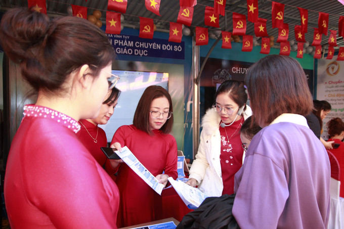 Cán bộ xã Vĩnh Tuy hướng dẫn người dân trải nghiệm dịch vụ công trực tuyến tại Hội chợ số.