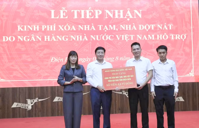 Ông Trịnh Công Văn, Quyền Giám đốc Ngân hàng Nhà nước chi nhánh Khu vực 3, trao tặng kinh phí hỗ trợ xóa nhà tạm, nhà dột nát cho tỉnh Điện Biên. Ảnh: TTXVN phát