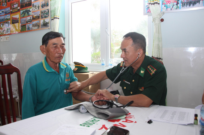 Chiến sĩ Đồn Biên phòng Gành Hào (tỉnh Cà Mau) khám bệnh cho người dân tham gia chương trình. Ảnh: Chanh Đa/TTXVN