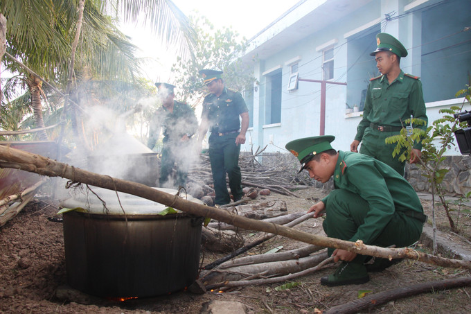 Chiến sĩ Đồn Biên phòng Gành Hào (Cà Mau) nấu các nồi bánh tét để gửi đến người dân tham dự chương trình. Ảnh: Chanh Đa/TTXVN