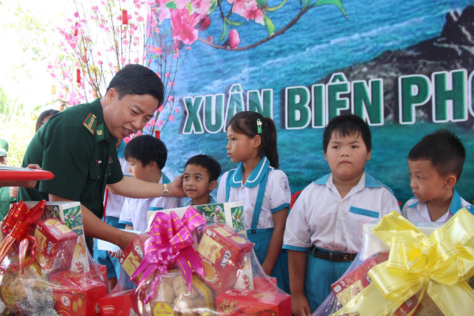 Đại tá Phạm Minh Giang, Chính ủy Ban chỉ huy Bộ đội Biên phòng Cà Mau trao tặng quà cho học sinh trên địa bàn. Ảnh: Chanh Đa/TTXVN