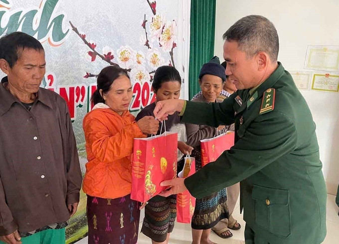 Thượng tá Đinh Quang Duyên, Chính trị viên Đồn Biên phòng Ba Tầng (Quảng Trị) trao quà Tết mừng Xuân Bính Ngọ 2026 cho đồng bào xã A Dơi. Ảnh: Hải Âu/TTXVN