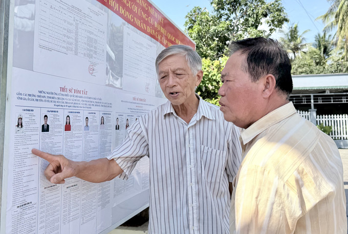 Cử tri xã Tri Tôn, An Giang xem danh sách cử tri được niêm yết công khai tại khu vực bỏ phiếu.