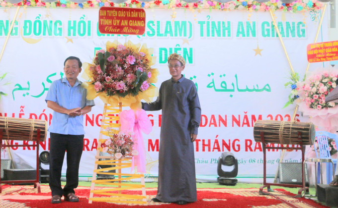 Ông Nguyễn Hữu Thịnh, Phó Trương Ban Tuyên giáo và Dân vận tỉnh An Giang (trái) tặng hoa chúc mừng Ban Đại diện Cộng đồng Hồi giáo Islam.