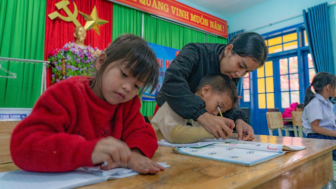 Cô Đinh Thị Học và 34 học sinh tại điểm trường sạt lở được chuyển về Trường PTDTBT Tiểu học Ngọc Linh để học tập. Ảnh: Khoa Chương/TTXVN