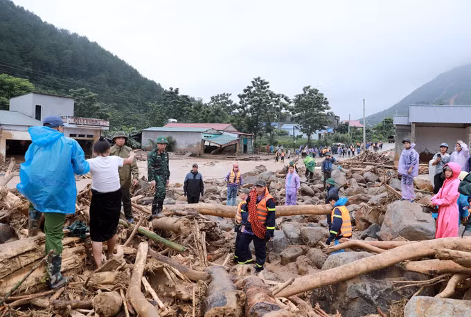 Các lực lượng chức năng phối hợp di dời người dân ra khỏi vùng nước lũ cô lập đến nơi ở an toàn. Ảnh: Quý Trung/TTXVN