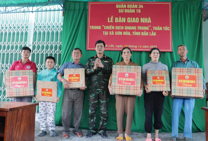 Thượng tá Đặng Thành Tuyên, Phó Chính ủy Sư đoàn 10, Quân đoàn 34 (Bộ Quốc phòng) tặng quà cho các hộ dân về nhà mới.