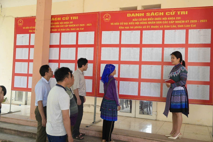 Cử tri xã Bản Lầu xem danh sách cử tri được niêm yết tại trụ sở xã. Ảnh: Hương Thu/TTXVN