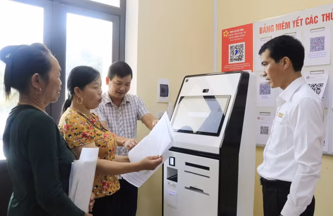 Chủ tịch UBND xã Việt Hồng Nguyễn Tiến Chiển hướng dẫn người dân thực hiện các thao tác trên Robot AI.