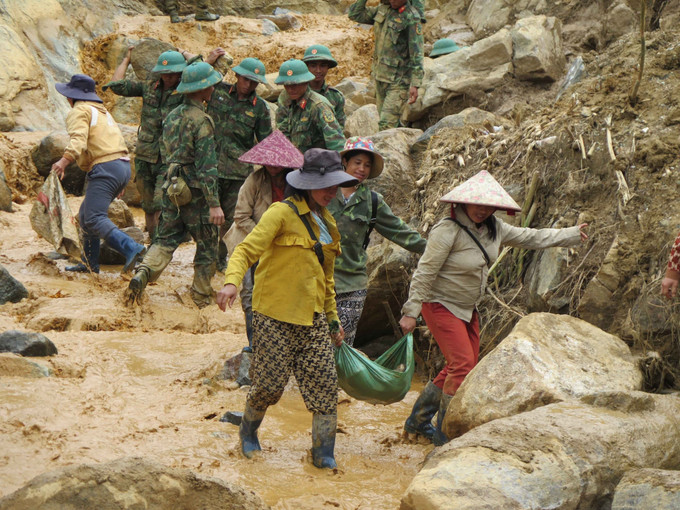 Người dân cùng các cán bộ, chiến sĩ Quân đoàn 34 triển khai công tác mở đường vào 5 thôn ở xã Ngọc Linh (Quảng Ngãi) bị cô lập do mưa lũ.