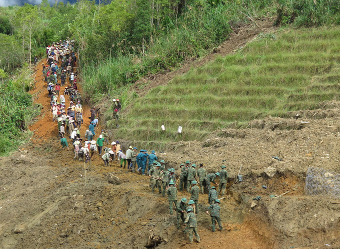 Người dân cùng các cán bộ, chiến sĩ Quân đoàn 34 triển khai công tác mở đường vào 5 thôn ở xã Ngọc Linh (Quảng Ngãi) bị cô lập do mưa lũ.