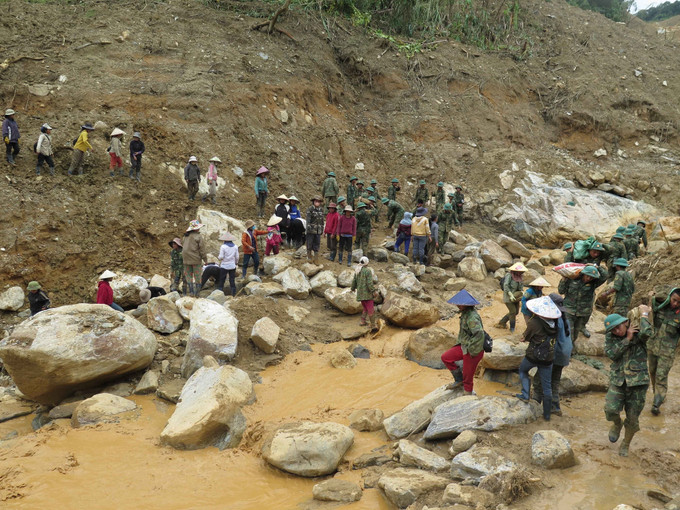 Người dân cùng các cán bộ, chiến sĩ Quân đoàn 34 triển khai công tác mở đường vào 5 thôn ở xã Ngọc Linh (Quảng Ngãi) bị cô lập do mưa lũ.