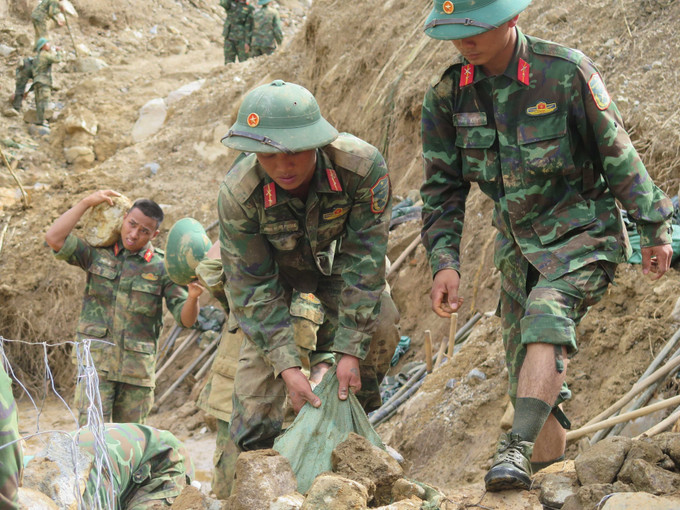 Cán bộ, chiến sĩ Quân đoàn 34 triển khai công tác mở đường vào các thôn bị cô lập do mưa lũ ở xã Ngọc Linh.