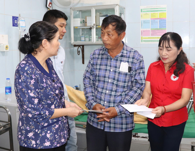Bí thư Tỉnh ủy Lai Châu Giàng Páo Mỷ trao hỗ trợ ban đầu cho người nhà bệnh nhân trong vụ sạt lở đất tại Bệnh viện Đa khoa tỉnh Lai Châu. Ảnh: TTXVN phát sat-lo-16052025-03.jpg