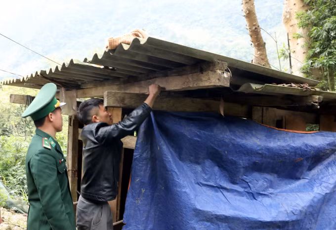 Chiến sĩ Đồn biên phòng Cửa khẩu quốc tế Nậm Cắn (Nghệ An) hướng dẫn người dân bản Trường Sơn, xã Nậm Cắn che chắn chuồng trại cho đàn trâu bò.