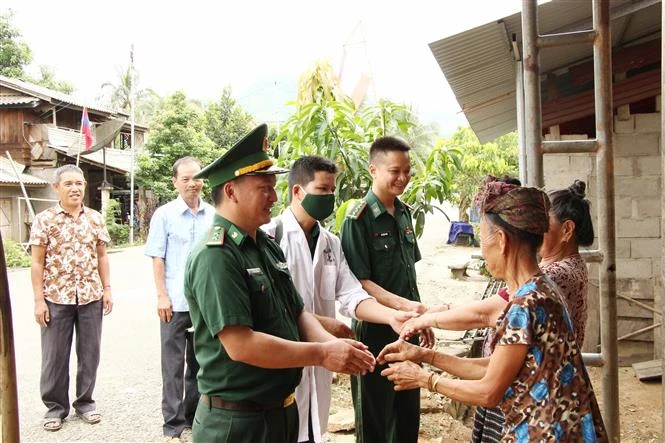 Đoàn cán bộ Đồn Biên phòng Cửa khẩu Chiềng Khương, Bộ Chỉ huy Bộ đội Biên phòng tỉnh Sơn La thăm, khám chữa bệnh, cấp phát thuốc miễn phí cho người dân bản Đán, huyện Mường Ét, tỉnh Hủa Phăn, Lào. Ảnh: Nguyễn Cường - TTXVN.
