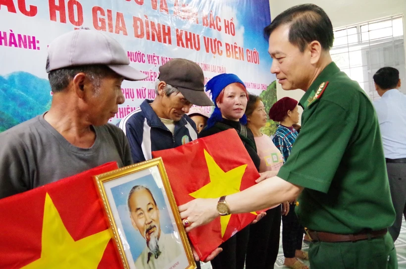 Đại tá Nguyễn Văn Hưng, Chính uỷ Bộ đội biên phòng tỉnh Lai Châu tặng cờ Tổ quốc và ảnh Bác Hồ cho người dân biên giới tại bản Tung Qua Lìn, xã Tung Qua Lìn. Ảnh: TTXVN phát