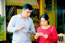 Anh Trần Trường Sơn, cán bộ Bảo hiểm xã hội huyện Thuận Châu tuyên truyền chính sách Bảo hiểm xã hội tự nguyện cho người dân. Ảnh: Quang Quyết - TTXVN