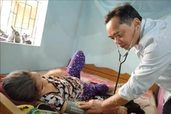 Bác sĩ Mấu Văn Phi khám bệnh cho bà Cao Thị Lính (95 tuổi) thôn Bầu Sang, xã Liên Sang (Khánh Vĩnh, Khánh Hòa). Ảnh: Thanh Vân - TTXVN