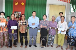 Phó Chủ tịch Ủy ban Mặt trận Tổ quốc Việt Nam tỉnh Sóc Trăng Lâm Dũng Liêm trao tiền hỗ trợ đến các hộ dân bị ảnh hưởng. Ảnh: Danh Chanh Đa - TTXVN