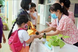 Giáo viên Trường Mầm non Tuổi thơ (Quận 8) hướng dẫn trẻ rửa tay trước khi vào lớp. Ảnh: Thu Hoài - TTXVN