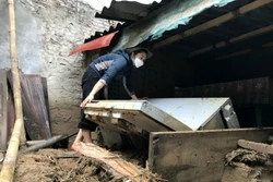 Người dân khối 1, thị trấn Mường Xén, Kỳ Sơn (Nghệ An), cố gắng tìm kiếm những tài sản còn sót lại sau trận lũ quét. Ảnh: Văn Tý-TTXVN