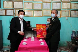 Đồng chí Nguyễn Xuân Thắng, Giám đốc Học viện Chính trị Quốc gia Hồ Chí Minh trao quà cho các hộ gia đình chính sách xã Tân Tiến. Ảnh: Nam Sương - TTXVN
