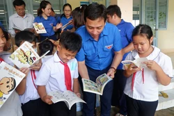 Bí thư Tỉnh đoàn Long An Trần Hải Phú với học sinh Trường tiểu học Nhơn Hòa tại buổi trao tặng "Tủ sách Đinh Hữu Dư". Ảnh: Đức Hạnh - TTXVN