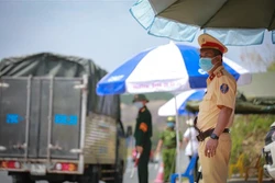 Tại mỗi chốt kiểm soát COVID-19 gồm 13 người từ các lực lượng cảnh sát giao thông, kiểm soát quân sự, cảnh sát cơ đông, công an huyện, cán bộ Y tế... Ảnh: Trọng Đạt - TTXVN 