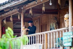 Trưởng thôn Sình Dỉ Gai trang trí homestay của gia đình. Ảnh: Nam Thái - TTXVN