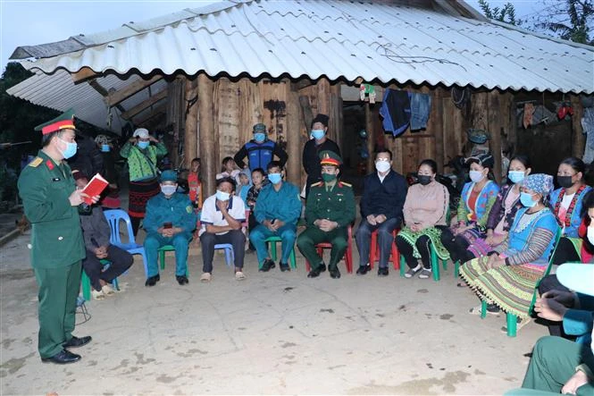 Cán bộ Ban Chỉ huy Quân sự huyện Than Uyên tuyên truyền, vận động người dân bản Noong Thăng, xã Phúc Than, huyện Than Uyên về các biện pháp phòng chống dịch COVID-19 và luật nghĩ vụ quân sự. Ảnh: Việt Hoàng - TTXVN