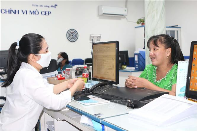 Nhân viên Tổ chức Tài chính vi mô (CEP) quận 8 tư vấn cho cô giáo Huỳnh Ngọc Bảo Sơn (phường 7, quận 8) về việc vay vốn để trả nợ và mở quán nước kiếm sống trong thời điểm dịch bệnh bùng phát. Ảnh: Thanh Vũ - TTXVN “Tiếp sức” cho người lao động trong mùa dịch - Bài 2 ảnh 1