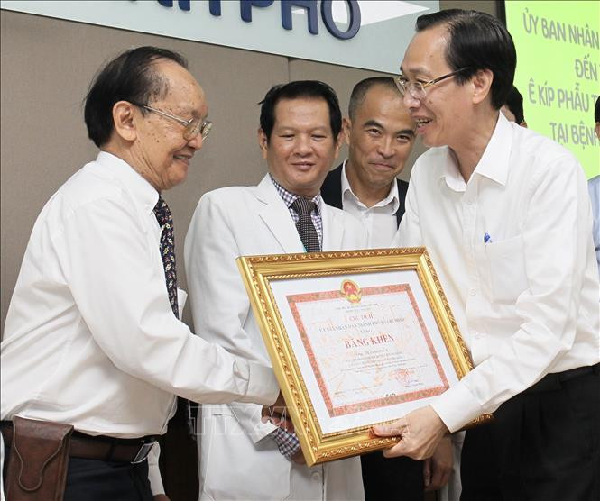 Phó Chủ tịch Thường trực UBND Thành phố Hồ Chí Minh Lê Thanh Liêm trao tặng bằng khen cho Giáo sư Trần Đông A - Cố vấn chuyên môn ca phẫu thuật. Ảnh: Đinh Hằng - TTXVN Thành phố Hồ Chí Minh: Sức khỏe cặp song sinh dính liền được tách rời tiến triển tốt ảnh 1