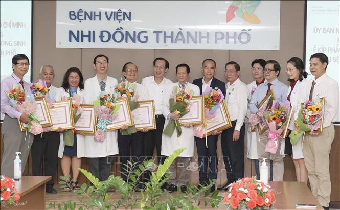 Tập thể y bác sỹ phẫu thuật, chăm sóc cặp song sinh Trúc Nhi - Diệu Nhi nhận khen thưởng của lãnh đạo UBND Thành phố Hồ Chí Minh. Ảnh: Đinh Hằng - TTXVN Thành phố Hồ Chí Minh: Sức khỏe cặp song sinh dính liền được tách rời tiến triển tốt ảnh 3