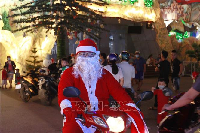 "Ông già Noel" cùng các phần quà chuẩn bị tặng trẻ em nhân dịp Giáng sinh. Ảnh: Thanh Vũ - TTXVN Thành phố Hồ Chí Minh tổ chức nhiều hoạt động chào đón năm mới 2021 ảnh 6