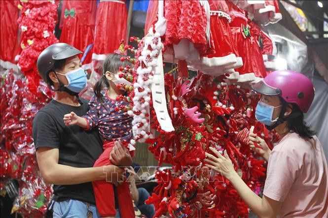 Nhiều gia đình mua sắm đồ Giáng sinh tại các cửa hàng trên đường Hải Thượng Lãn Ông (Quận 5). Ảnh: Thanh Vũ - TTXVN Thành phố Hồ Chí Minh tổ chức nhiều hoạt động chào đón năm mới 2021 ảnh 1