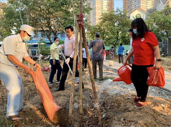 Cán bộ, công-viên chức cùng người dân thành phố Thủ Đức tham gia trồng cây. Ảnh: Hồng Giang - TTXVN Thành phố Hồ Chí Minh quyết tâm chống biến đổi khí hậu, bảo vệ môi trường ảnh 1