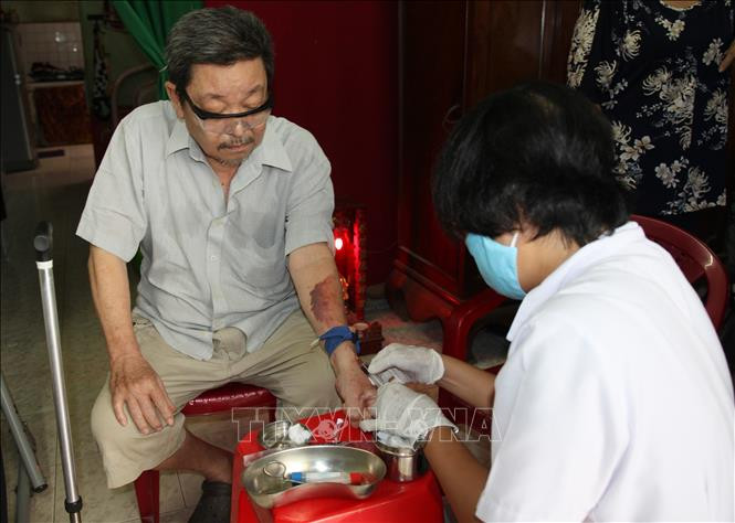 Điều dưỡng Trạm Y tế phường 16, quận Gò Vấp đến nhà lấy máu xét nghiệm cho người bệnh. Ảnh: Đinh Hằng - TTXVN Ngành Y tế Thành phố Hồ Chí Minh “cất cánh" - Bài 2 ảnh 1