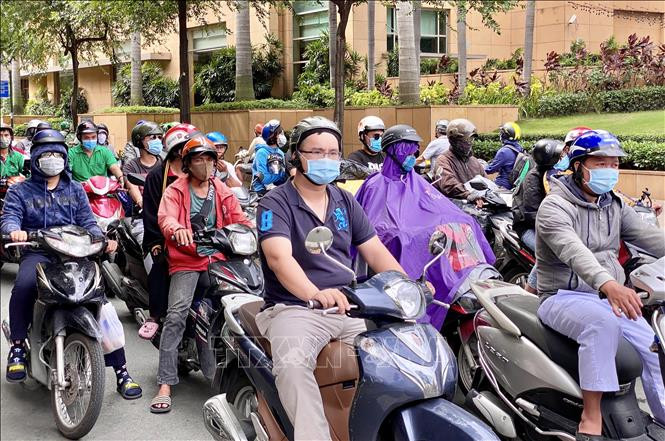 Người dân nghiêm túc đeo khẩu trang khi tham gia giao thông. Ảnh: Hồng Giang - TTXVN Thành phố Hồ Chí Minh tiếp tục rà soát người từng đến Đà Nẵng, khoanh vùng cách ly những trường hợp tiếp xúc với người mắc COVID-19 ảnh 5