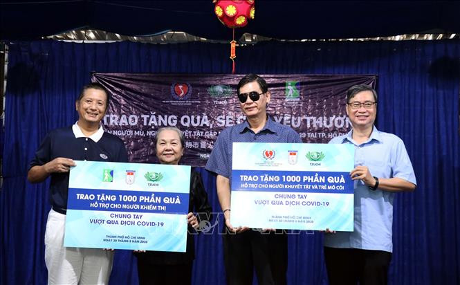 Ông Vương Đức Hoàng Quân, Chủ tịch Liên hiệp các tổ chức hữu nghị Thành phố (phải) và ông Chen Ta Yu, Trưởng đại diện tổ chức Tzu Chi (trái) trao tượng trưng quà cho đại diện Hội Bảo trợ Người khuyết tật và Trẻ mồ côi Thành phố và Hội Người mù Thành phố Hồ Chí Minh. Ảnh: Xuân Khu -TTXVN Dịch COVID-19: Tặng 2.000 phần quà cho người khuyết tật và khiếm thị tại Thành phố Hồ Chí Minh ảnh 5