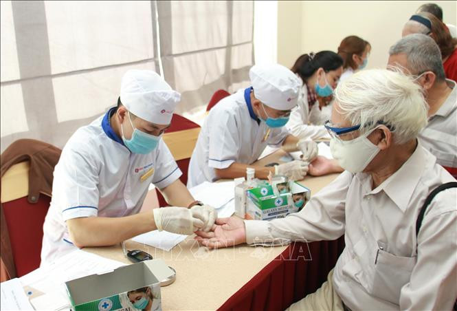 Bác sỹ lấy mẫu xét nghiệm đường huyết cho người dân. Ảnh: Đinh Hằng - TTXVN Thành phố Hồ Chí Minh hưởng ứng Ngày đái tháo đường thế giới ảnh 2