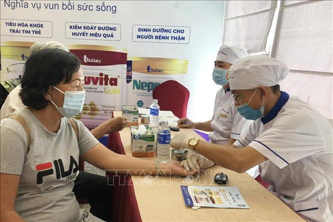 Bác sỹ lấy mẫu xét nghiệm đường huyết cho người dân. Ảnh: Đinh Hằng - TTXVN Thành phố Hồ Chí Minh hưởng ứng Ngày đái tháo đường thế giới ảnh 3