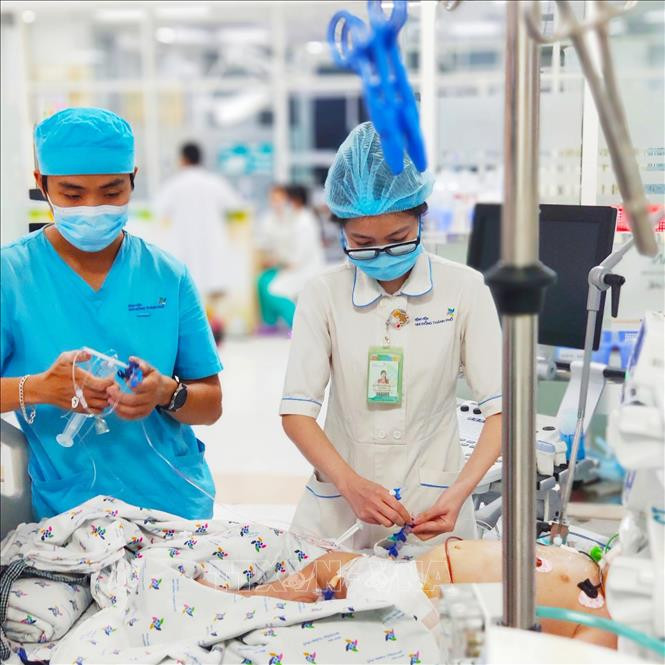Các bác sỹ Bệnh viện Nhi đồng Thành phố đang điều trị tích cực cho bệnh nhi sốc sốt xuất huyết nặng. Ảnh: TTXVN phát Thành phố Hồ Chí Minh: Liên tiếp cứu sống hai bệnh nhi sốc sốt xuất huyết nặng ảnh 1