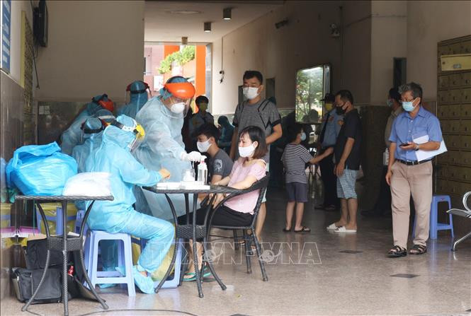 Lực lượng y tế túc trực để lấy mẫu xét nghiệm cho toàn bộ cư dân chung cư. Ảnh: Đinh Hằng - TTXVN Thành phố Hồ Chí Minh xử lý các điểm liên quan đến bệnh nhân COVID-19 ảnh 3