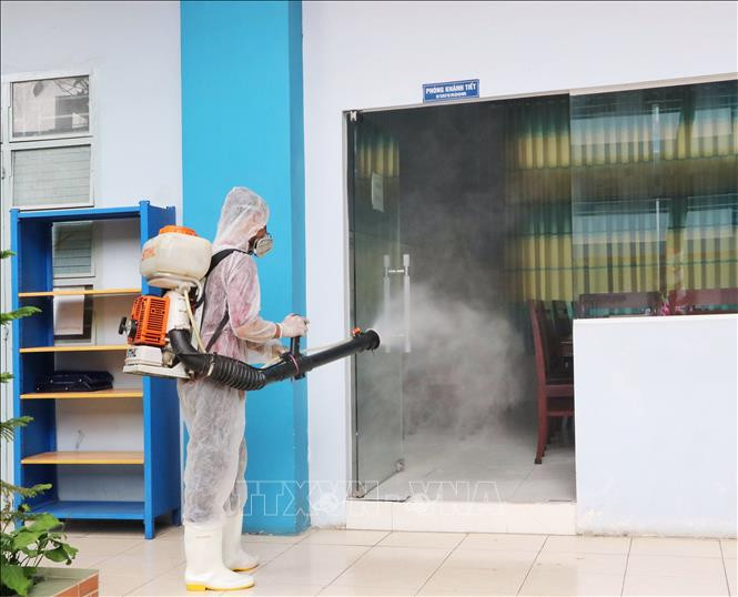 Nhân viên y tế phun khử trùng khu vực phòng cách ly riêng tại trường Trung học phổ thông Nguyễn Du, Quận 10. Ảnh: Thu Hương - TTXVN Thành phố Hồ Chí Minh xử lý các điểm liên quan đến bệnh nhân COVID-19 ảnh 7