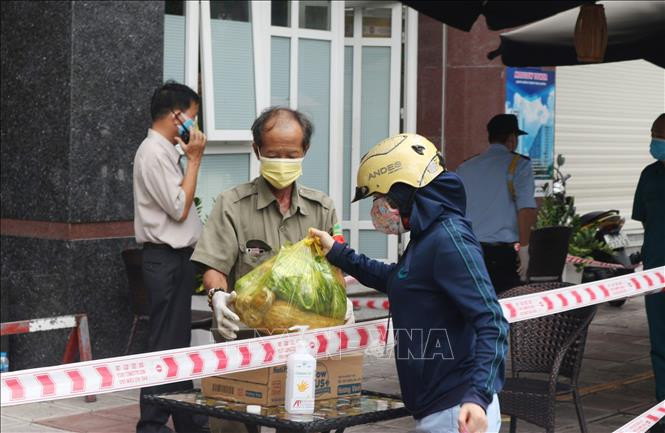 Lực lượng bảo vệ hỗ trợ người dân vận chuyển hàng hóa, nhu yếu phẩm. Ảnh: Đinh Hằng - TTXVN Bí thư Thành ủy Thành phố Hồ Chí Minh Nguyễn Thiện Nhân: "Rà soát kỹ người trở về từ Đà Nẵng, quyết liệt chặn người nhập cảnh trái phép" ảnh 1